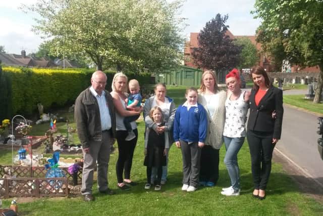 Callous thieves have stolen ornaments, lights and cash from a money box a money box  on at least four graves of stillborn and young babies at Kirkbys Kingsway Cemetery. Families are pictured with MP Gloria De Piero.