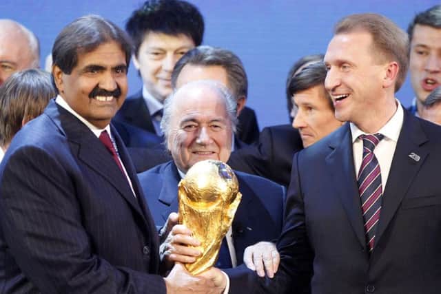 FIFA President Sep Blatter is flanked by Russian Deputy Prime Minister Igor Shuvalov, right, and Sheikh Hamad bin Khalifa Al-Thani, Emir of Qatar, after the announcement that Russia will host the  World Cup 2018 and Qatar 2022.