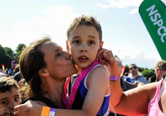 Bailey Matthews  8 from Doncaster  gets a kiss from his mother  Julia  after he crossed the finish line  to complete his first ever triathlon at Castle Howard on sat.