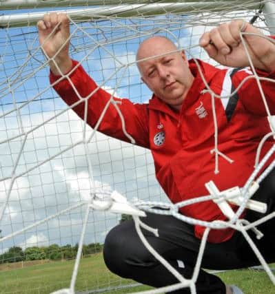 Paul Shelton Chairman of the Mansfield Boys Football Club inspects the portable nets which have been cut.
