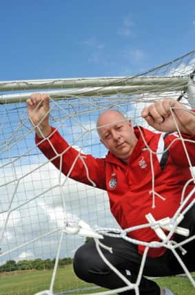 Paul Shelton Chairman of the Mansfield Boys Football Club inspects the portable nets which have been cut.