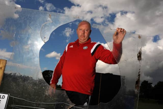 Paul Shelton, chairman of Mansfield Boys F.C. with some of the perpex roofing panel that has been ripped off the dug-out and disgarded in the near-by wooded area.