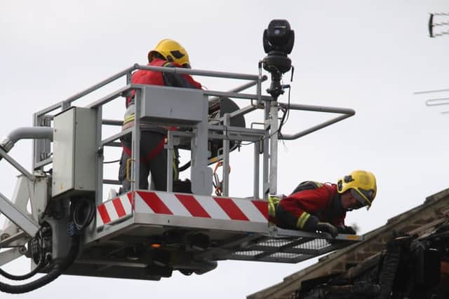 Fire crews are lifted closer to the scene of a fire, in Riddings, near Alfreton,