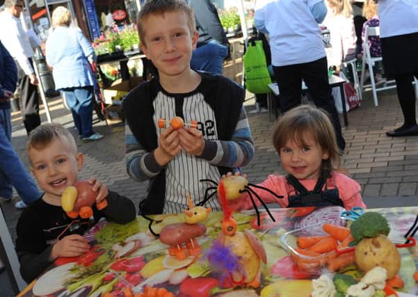 Isabella and Zak Carrington and Bobbi Hickling get to grips with some vegetable critters at the new Sutton Market on Saturday.