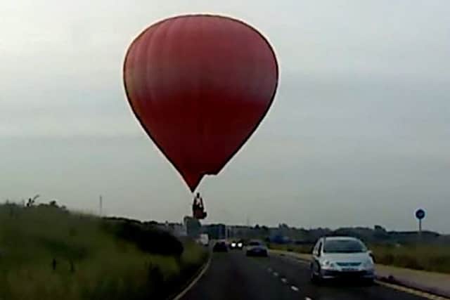 A hot air balloon gave drivers a scare as it landed on a field next to a Southport coastal road.
