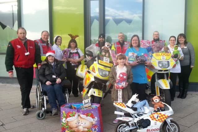 A selection of the gifts collected last year, (2014) with Blood Bike volunteers and childrens ward staff.