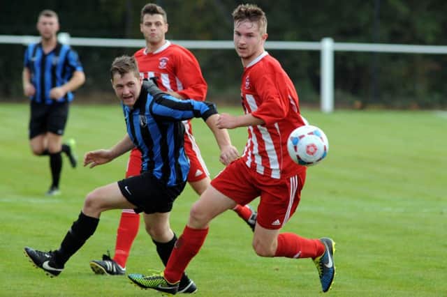 Tim Moore (centre) in action for Selston earlier this season.