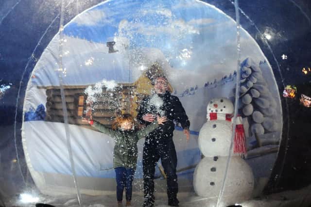 Kirkby Christmas lights.   Ashley and Chloe Savage from Kirkby get the snow flying in a giant snowdome.