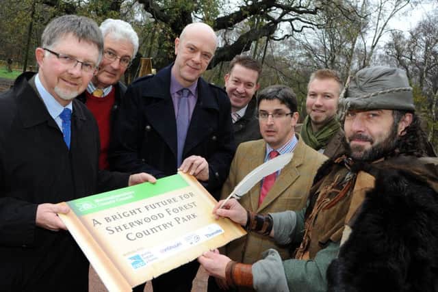 Robin Hood, aka, Ade Andrews, puts his name to the contract for the RSPB to take over the management of Sherwood Forest Country Park, with from left, Coun. Alan Rhodes, Patrick Candler chief executive of the Sherwood Forest Trus, Coun. John Knight, Kevin Smith Consortium Atractions, Nick Brown from the Thoresby Estate and RSPB area manager, Michael Copleston.