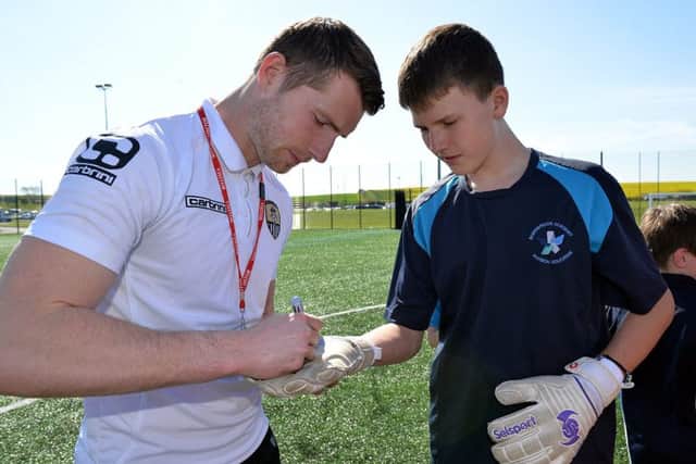 Notts County footballers visited Shirebrook Academy as part of the schools language week, pictured signing a glove is goalkeeper Fabian Spiess