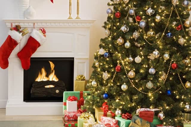 Christmas tree with presents and fireplace with stockings --- Image by © Royalty-Free/Corbis
