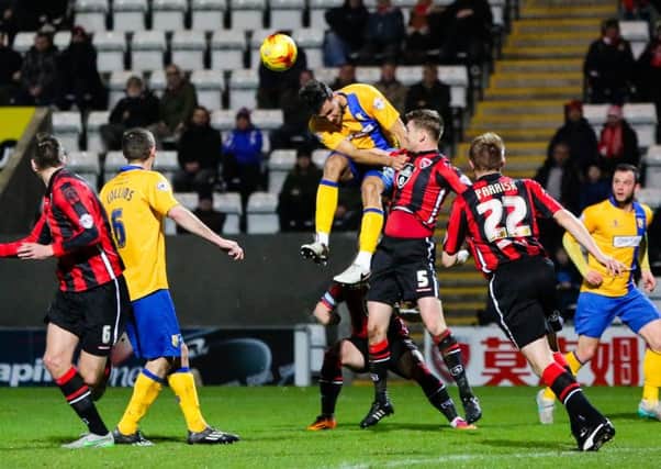 Mansfield Town's Ryan Tafazolli jumps to head the ball - Pic Chris Holloway - The Bigger Picture