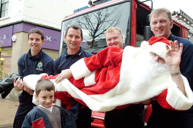 Mansfield firefighters give Santa a helping hand into Debenhams in the shopping centre in November 2006, watched by Otto Vout, then aged five, and his bear Spencer.