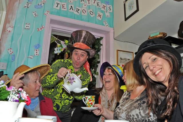 Nygel serves up anniversary tea to some of his regulars, from left, Christine Owens, Denise Eatherington, Sue Petrie and Maria Owens, during a tea party at the Mad Hatter's Tea Room based in Alice's Antiques in Kimberley on Saturday.