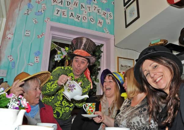 Nygel serves up anniversary tea to some of his regulars, from left, Christine Owens, Denise Eatherington, Sue Petrie and Maria Owens, during a tea party at the Mad Hatter's Tea Room based in Alice's Antiques in Kimberley on Saturday.