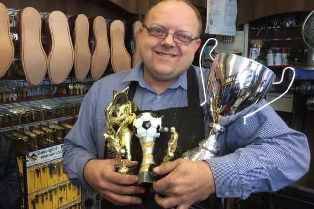 David Lee, manager of Mansfield's Quality Shoe Repairs & Key Cutting Services, with some of the trophies which could be won.