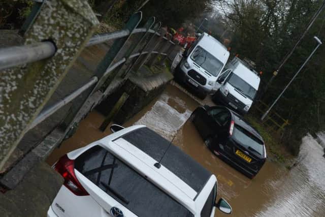 One car has been shifted downstream by the force of the water.
