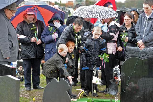 Floral tributes are layed with the tiny white coffin by family and friends of baby Tiger Brazier-Bennett.