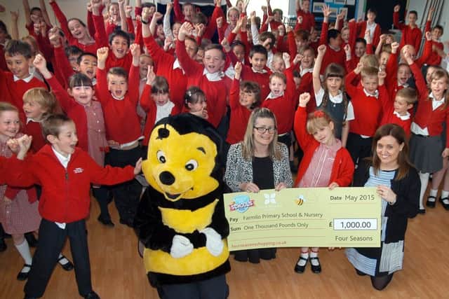 Mansfield Shop for Schools 2015 winners Farmilo Primary School receive their cheque for Â£1,000 from Rebekah O'Neil of the Four Seasons, with pupils and head teacher Suzanne Tryner.