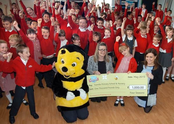 Mansfield Shop for Schools 2015 winners Farmilo Primary School receive their cheque for Â£1,000 from Rebekah O'Neil of the Four Seasons, with pupils and head teacher Suzanne Tryner.
