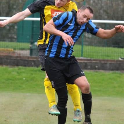 Hucknall midfielder Joe Ashurst (yellow) challenges Damien James, who netted the winner for Selston in the first-half.