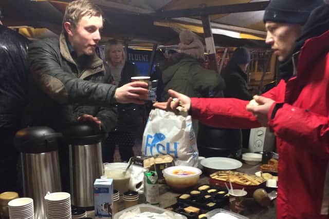 Councillor Tom Hollis helps volunteers serve hot food to the 30-40 people who are now attending a soup kitchen most nights of the week.
