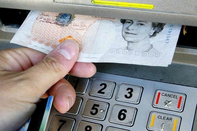 File photo dated 04/04/06 of a person withdrawing money from a cashpoint as Two banks partly owned by the state have been urged by MPs to drop restrictions on customers with basic bank accounts using cash machines run by other banks or third parties. PRESS ASSOCIATION Photo. Issue date: Friday August 31, 2012. The Commons Treasury Committee said the rules imposed by RBS and Lloyds TSB, both of which needed a taxpayer bailout following the 2008 banking crisis, risked compromising the cash machine network. The MPs said the impact of the rules could hit the poorest hardest, for potentially only a small financial gain for the banks. Barclays, HSBC and Santander - which is due to takeover RBS branches in England and Wales following the 2008 bailout - were praised by the committee for providing basic bank account holders with unrestricted access to cash machines operated by third parties. See PA story POLITICS Banks. Photo credit should read: Gareth Fuller/PA Wire