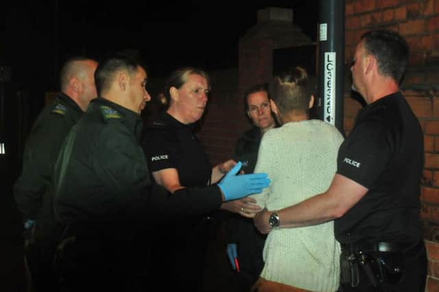 Police and paramedics work together to take in a reveler on a night out.