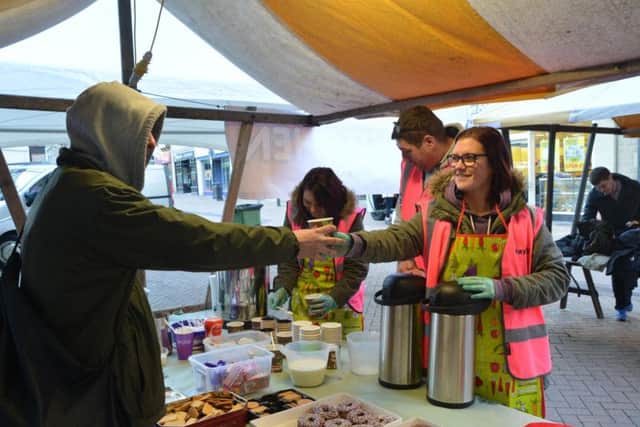 Volunteers put food in the bellies of homeless peop eon the market