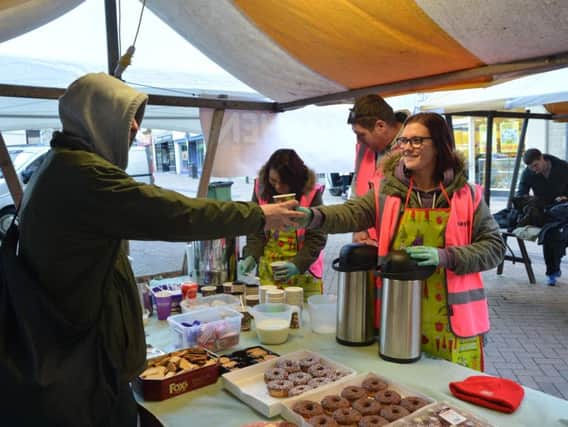 Volunteers put food in the bellies of homeless peop eon the market