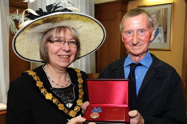 The chairman of Nottinghamshire County Council, Coun. Cybil Fielding, presents Derrick Tilley with his naval medal at County House in Mansfield on Tuesday.