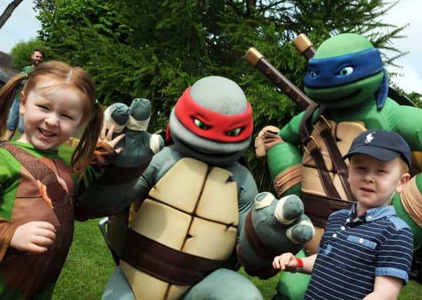 High fives for Harrison and Alana Lye when they met Ninja Turtles, Leo and Raff during a visit to the White Post Farm on Saturday.