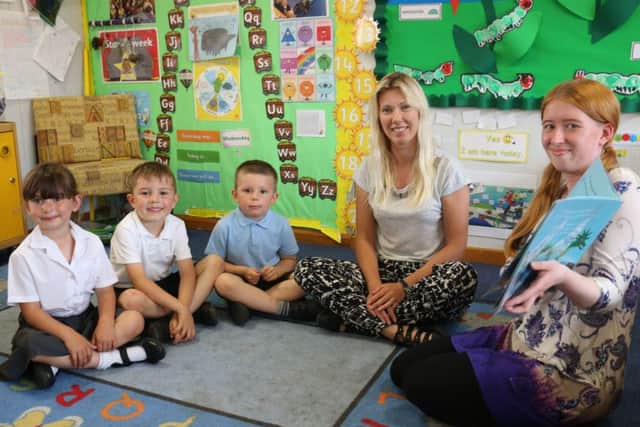 Laura, right, reads a story to pupils Daya Revill, Ryan Matthews and  Noah Wombwell, joined by Miss Rafton.