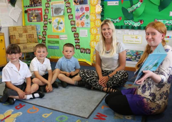 Laura, right, reads a story to pupils Daya Revill, Ryan Matthews and  Noah Wombwell, joined by Miss Rafton.
