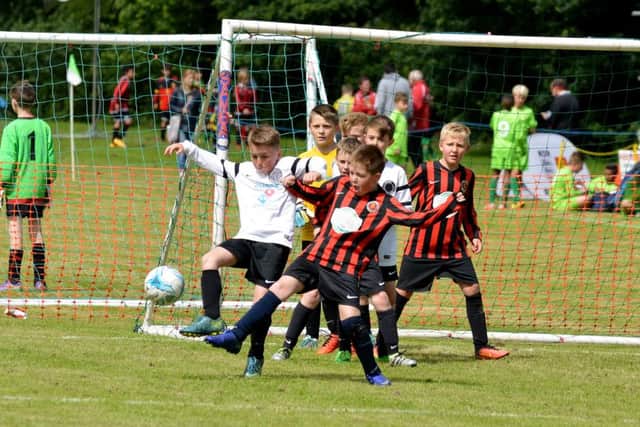 GOALMOUTH SCRAMBLE -- a battle for the ball in front of goal as the action hots up during Priory Celtics annual tournament.