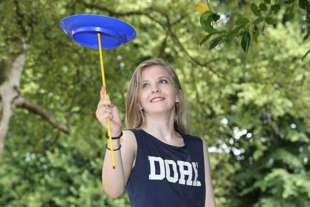 Sophie Whitby, 12, from Mansfield Woodhouse, learns how to spin plates at Parkfest. Picture by Mark Fear.