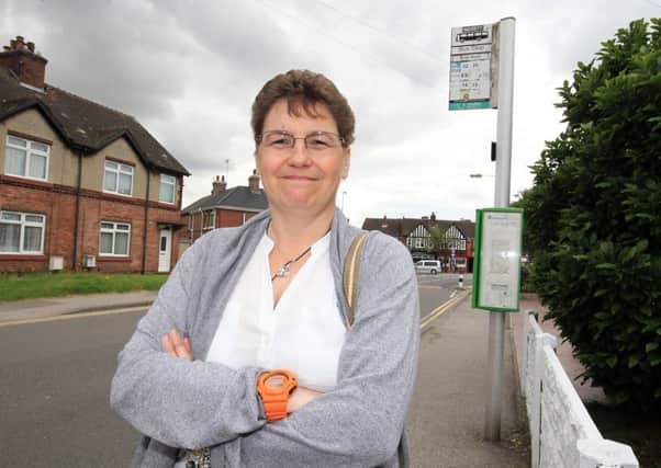 Carole Crane is angry that bus service are being cut in Ollerton and could mean her transport bill to work more than doubling. Carole is pictured at her bus stop on Briar Road.