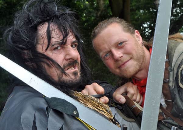 Robin Hood, (Steve Warrington), and the Sheriff of Nottingham (Mark Williams) cross swords at the opening ceremony for the 32nd annual Robin Hood Festival on Monday.