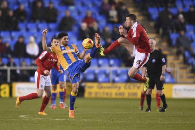 Barnsley 's  Marley Watkins kicks high with Shrewsbury's Nathaniel Knight-Percival.