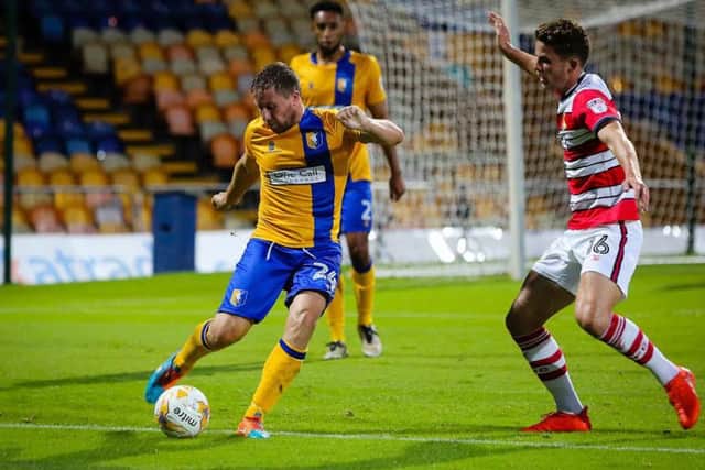 Mansfield Town's Jamie McGuire clears the danger - Pic by Chris Holloway