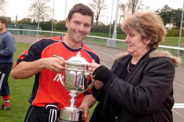 John Robinson, captain of Sutton Central, is presented with the Mansfield Sunday League Premier Cup by Kath Rowan after their win over Skegby United. 09-0943-2