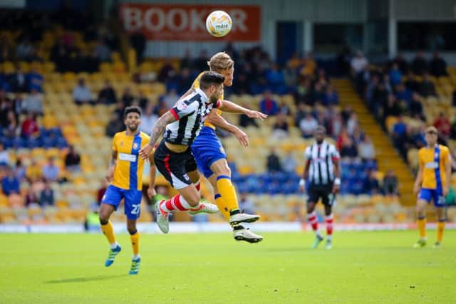Mansfield Town's Kevan Hurst wins the header - Pic by Chris Holloway