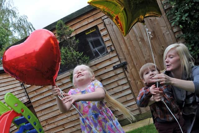 Helen Darby and her children Enya and Wesley, release balloons with messages of love for their dad Nathan.