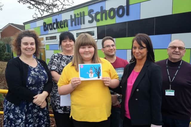 Hazel Clark and her winning Chrtistmas card at the presentation ceremony with (from left) art teacher Emma Gladwin, mum Verity Timms, stepdad Chris Woodhouse, MP Gloria De Piero and Vic Handley, from Van Elle.