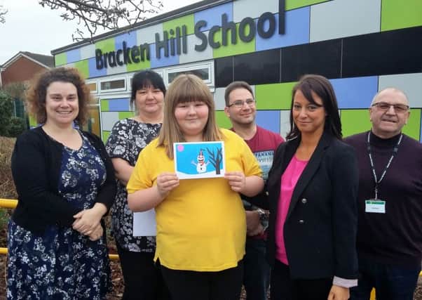 Hazel Clark and her winning Chrtistmas card at the presentation ceremony with (from left) art teacher Emma Gladwin, mum Verity Timms, stepdad Chris Woodhouse, MP Gloria De Piero and Vic Handley, from Van Elle.