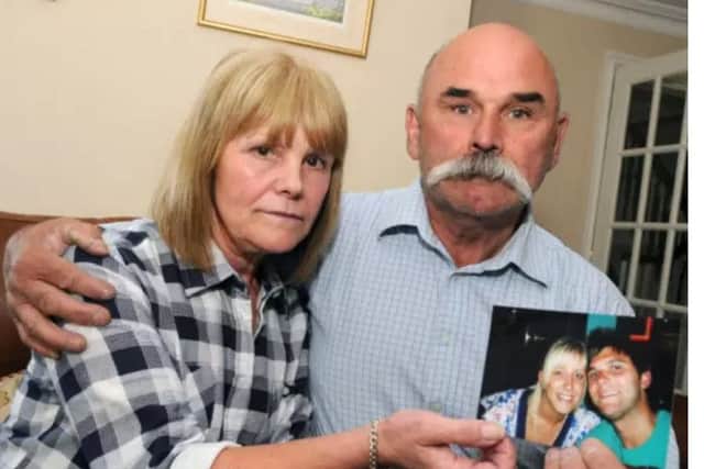 Sharon and Geoff Winter hold a photograph of their son Luke.