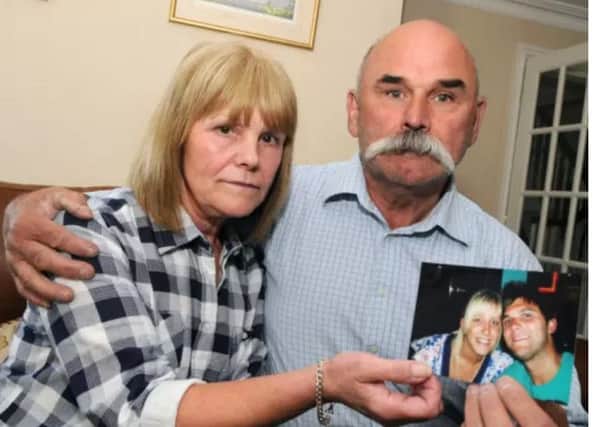 Sharon and Geoff Winter hold a photograph of their son Luke.