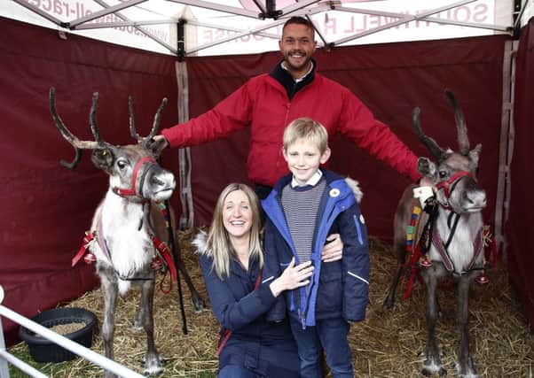 Reindeers Mistletoe and Chester pose for photos with a youngster and his mum.