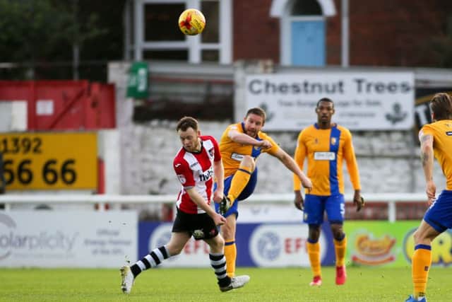 Mansfield Town's Jamie McGuire clears from midfield against Exeter on Saturday. Pic by Chris Holloway