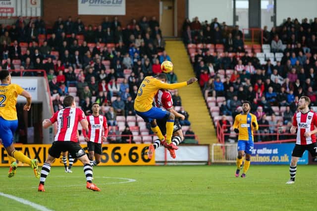 Mansfield Town's Krystian Pearce wins the header - Pic by Chris Holloway